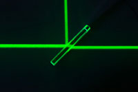 Das Bild zeigt einen mit einem teildurchlässigen Spiegel aufgeteilten Laser in einer optischen Bank